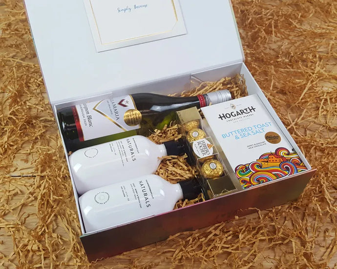 Open Giftbox with body products, wine and chocolate inside