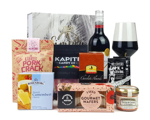 Giftbox with packaged food and wine in front