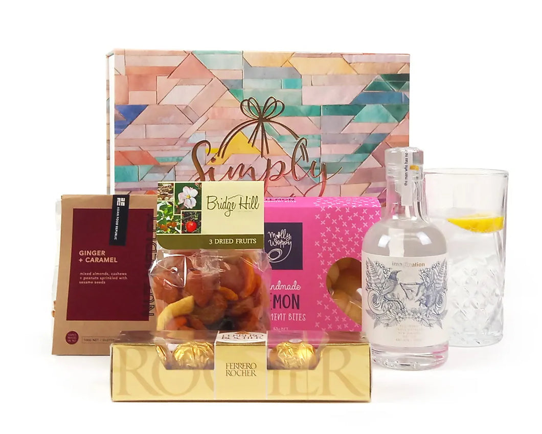 Giftbox with food treats and gin in front