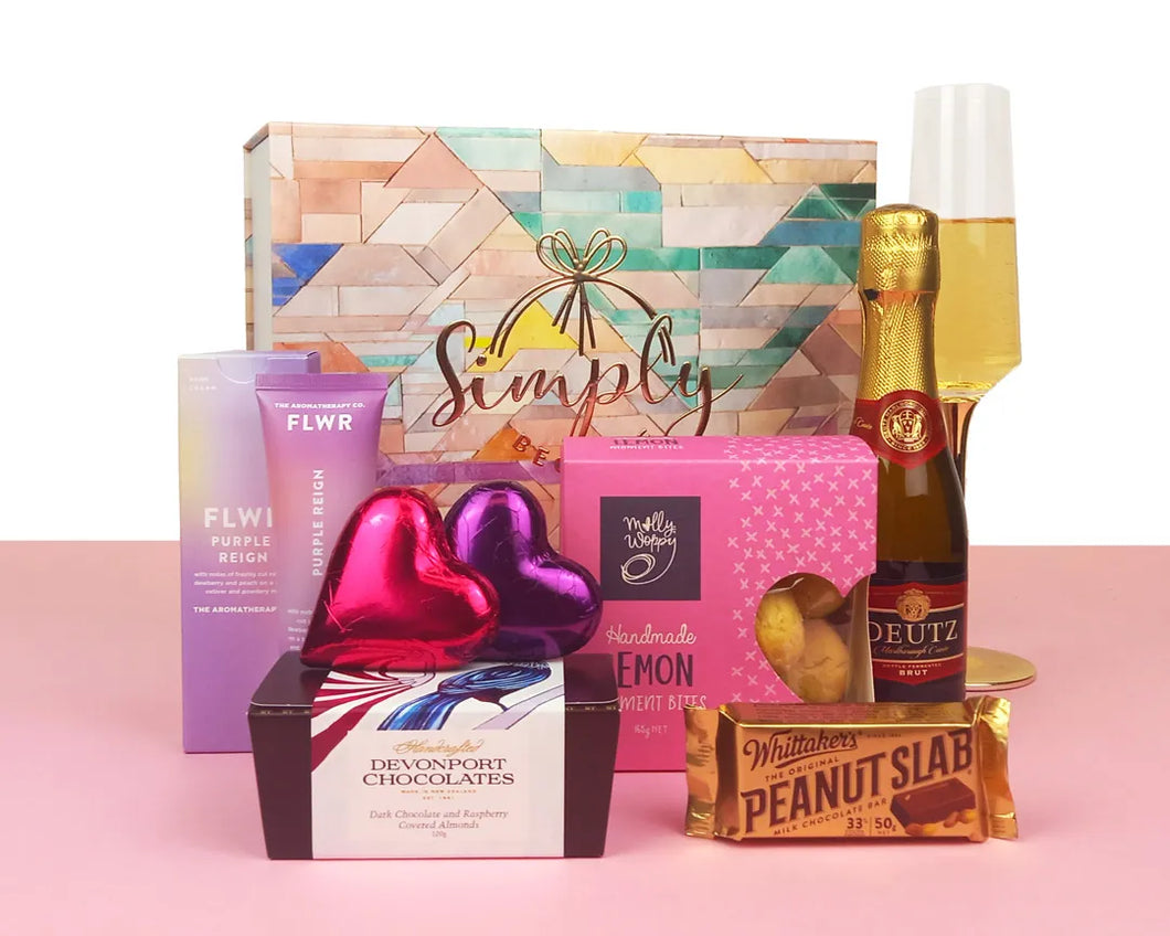 Giftbox with sweet treats and wine in front