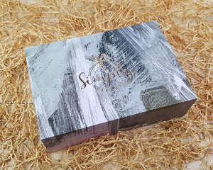 Simply Because black and white gift box exterior sitting on straw background